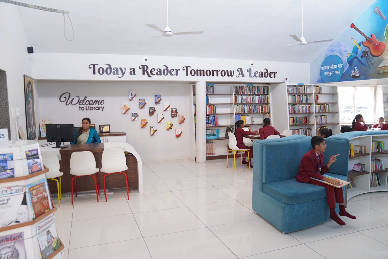 A lively library scene in Gujarat with students engaged in study, overseen by a librarian.